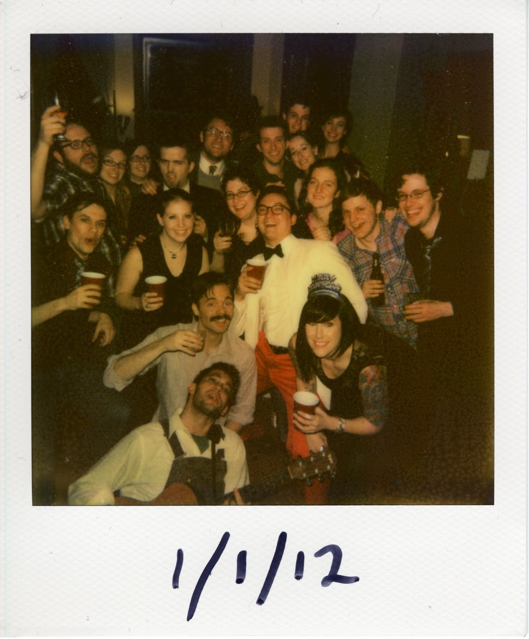 A group of people crowding in holding drinks to celebrate the New Year