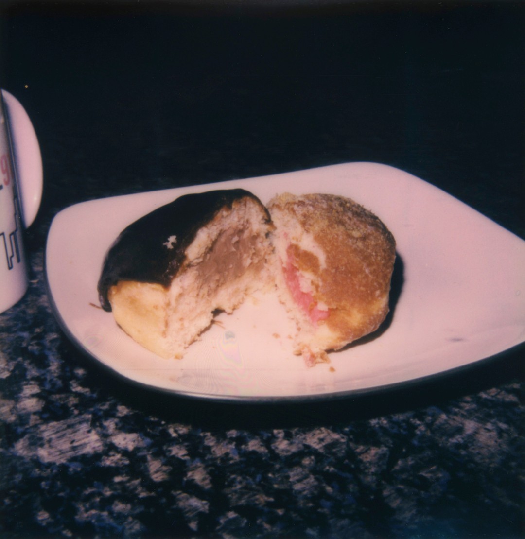 Two halfs of two filled donuts on a square plate