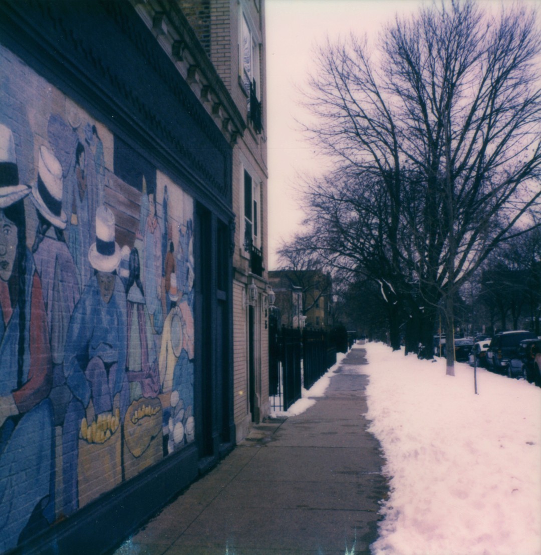 The southeast corner of Montrose and Paulina looking south. We can see a colorful mural of Ecuadorian workers making tortillas.