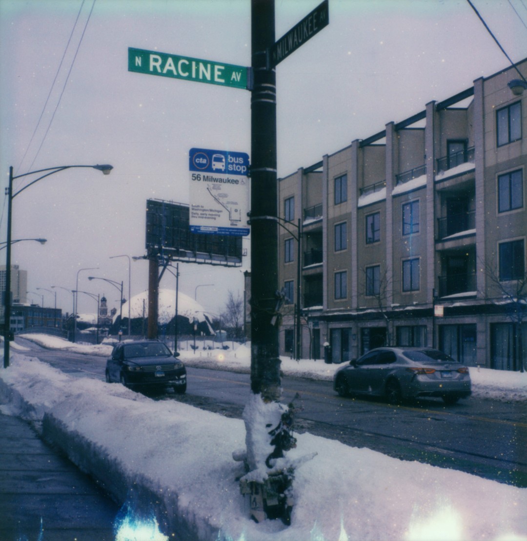 The intersection of Milwaukee Avenue and Racine Avenue in Chicago. There is a bike buried in snow.