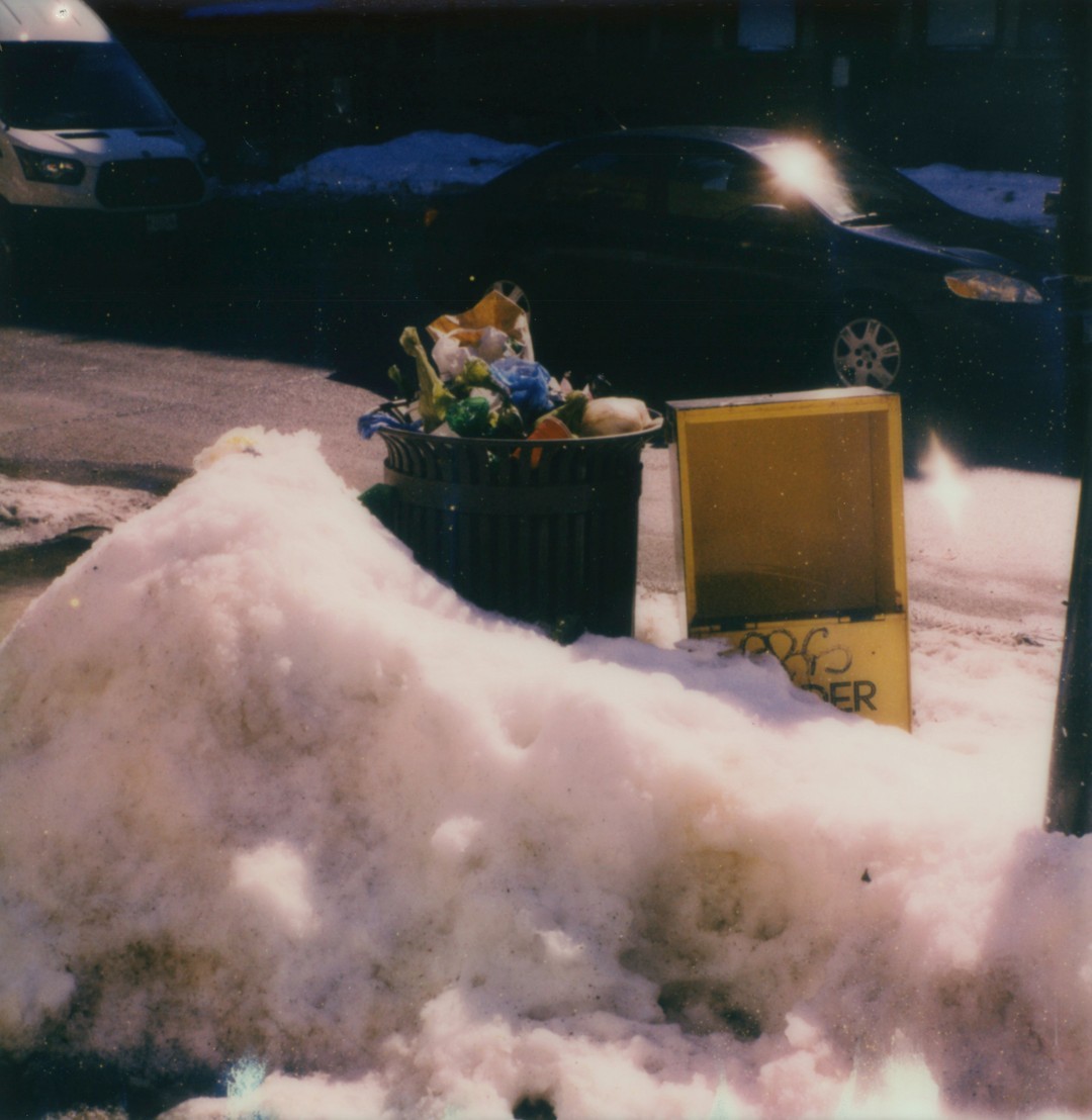 Trash in snow on a Chicago street.